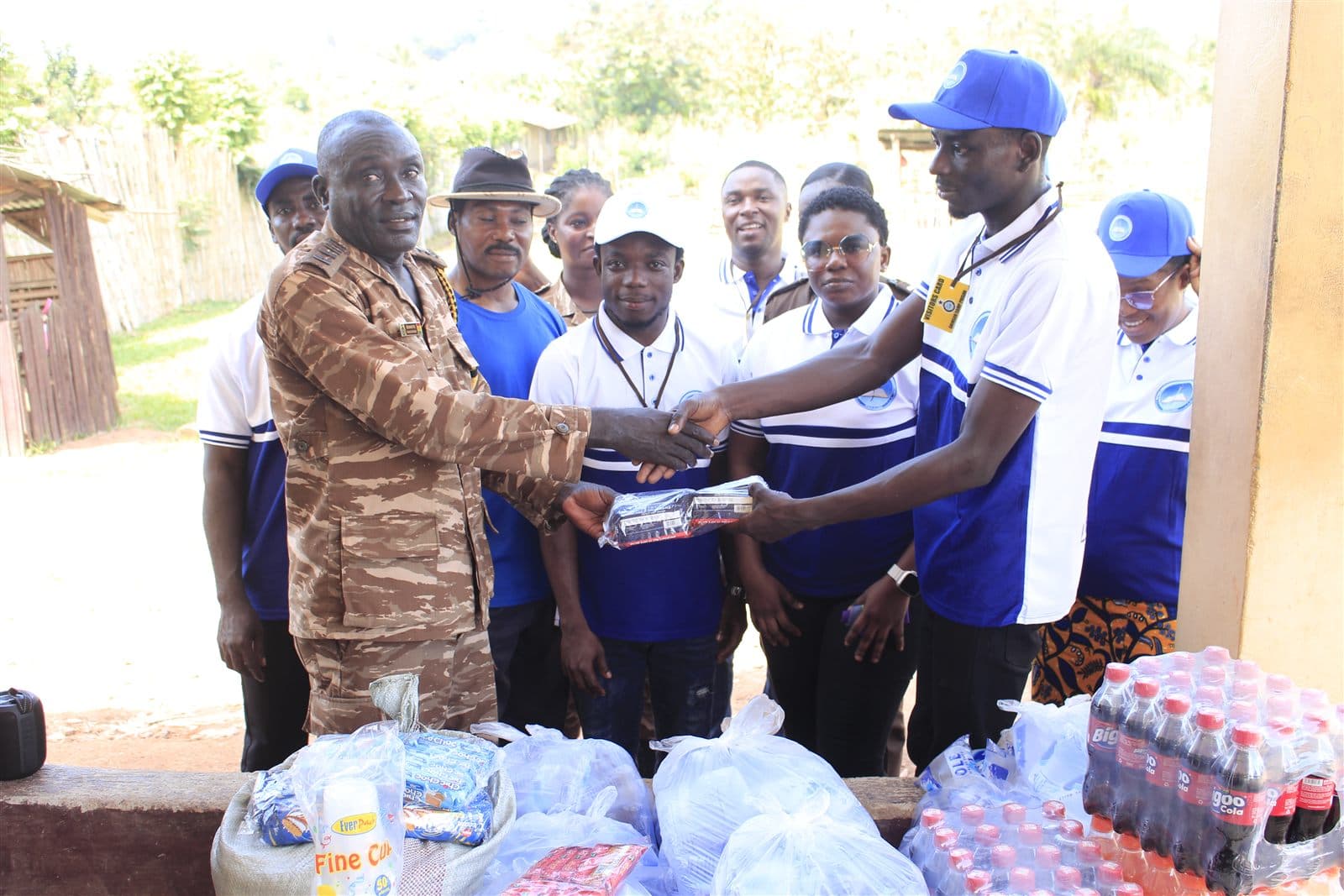A prison officer receives donated items from a Bethel Inspiration team member at Ahinsan Prison
